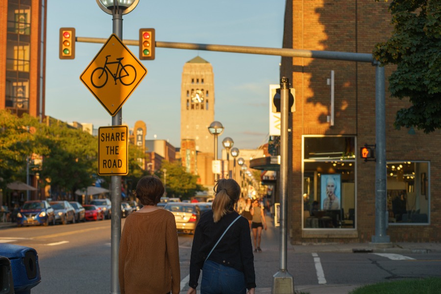 Two people walking east on Liberty Street in Ann Arbor. Lighting indicates the sun is setting